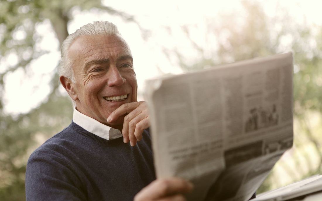Smiling older man reading at home