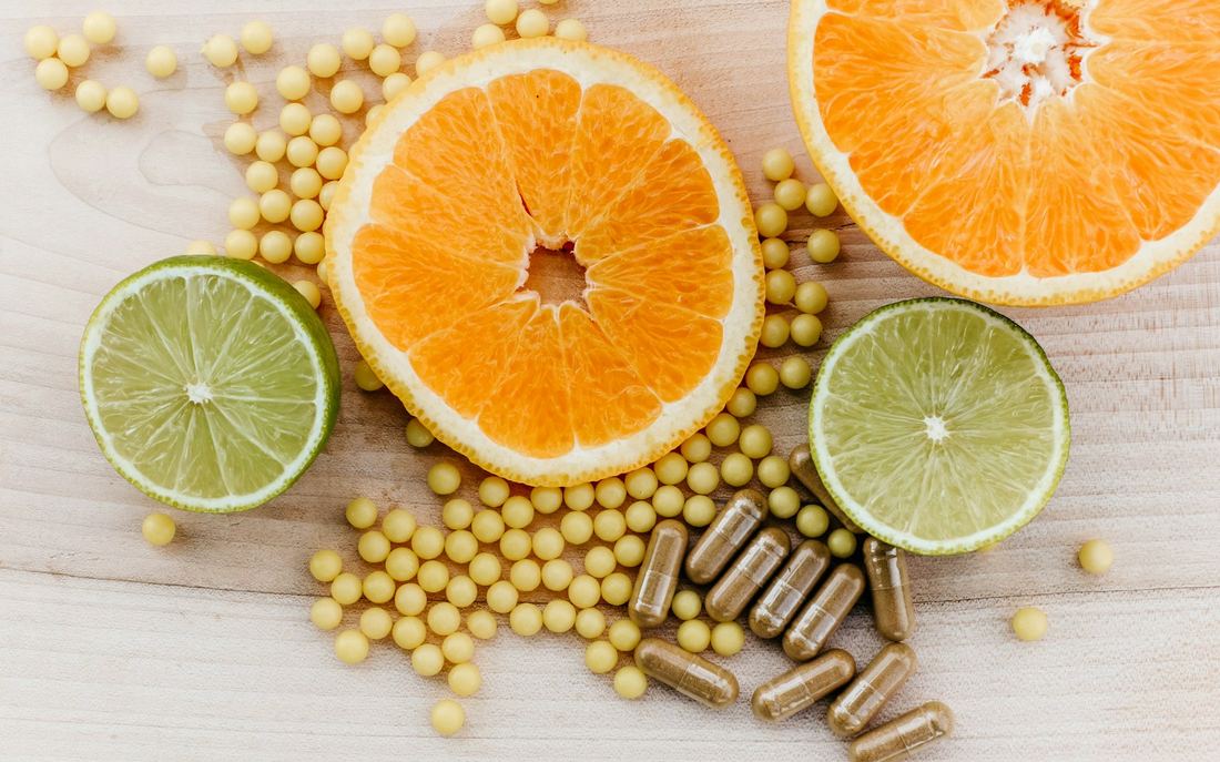 Citrus slices and supplement capsules on a wooden table